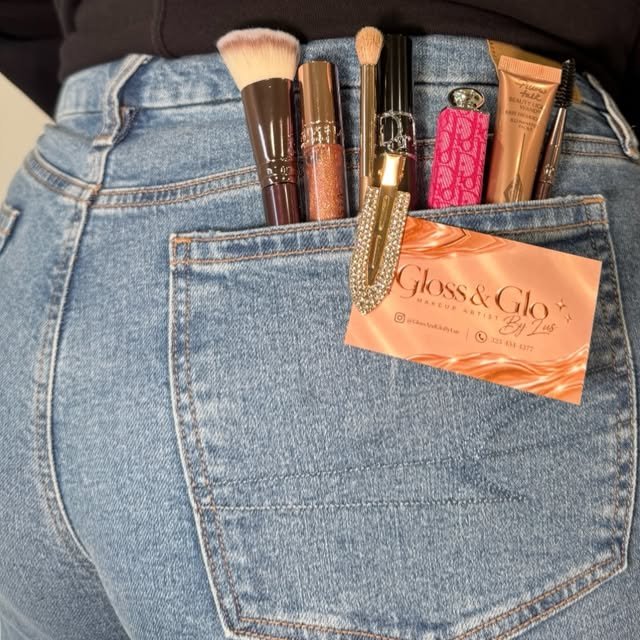 Makeup brushes tucked into a back pocket with a Gloss & Glo card